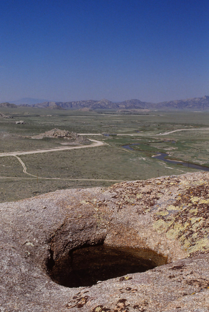 Scenic view of Little Skunk Granite Rock Pool 1989-06-08, #0221, with Independence Rock in distance; has fairy shrimp; Pathfinder National Wildlife Refuge